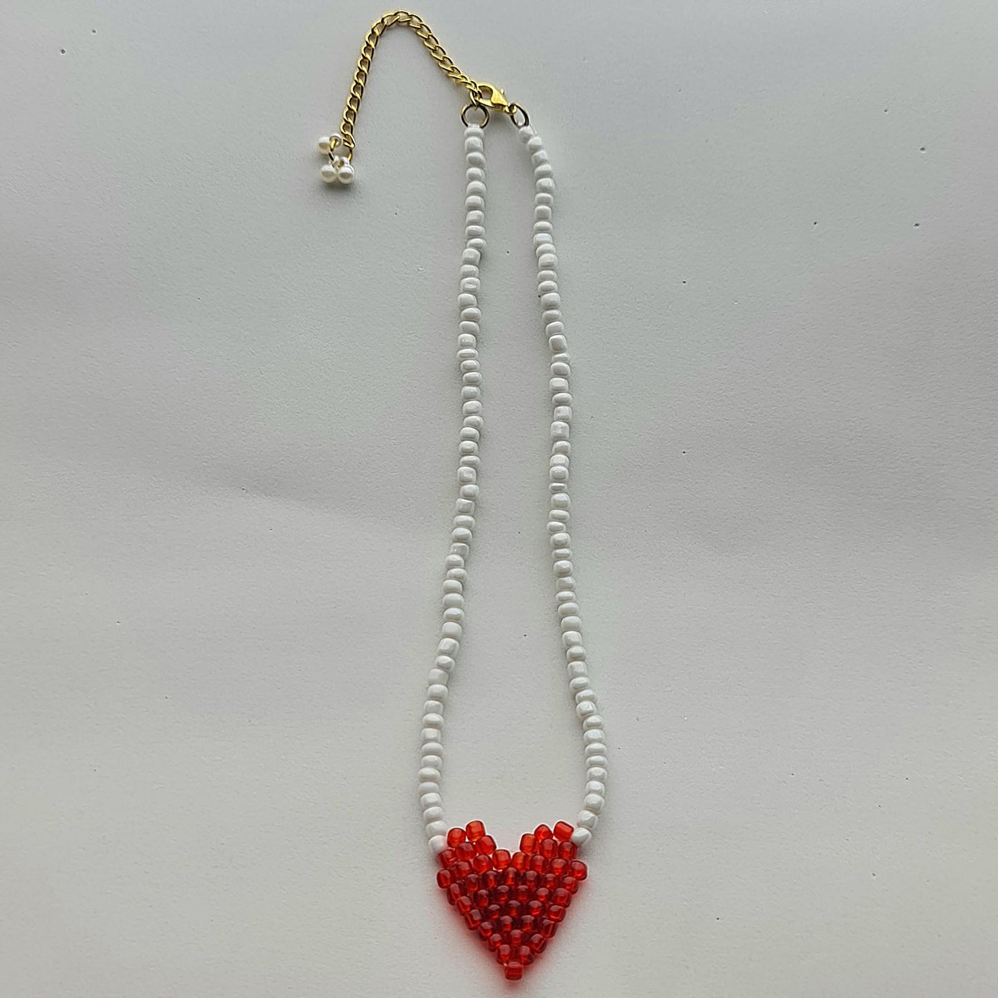 Necklace with a red heart-shaped pendant on a white background