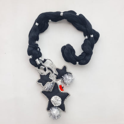 A black fabric bracelet with silver beaded trim and a dangling star-shaped charm decorated with silver beads, a clear rhinestone, and a small red accent, shown on a plain white background.