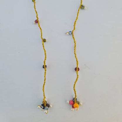 Long necklace with colorful beads on a light gray background