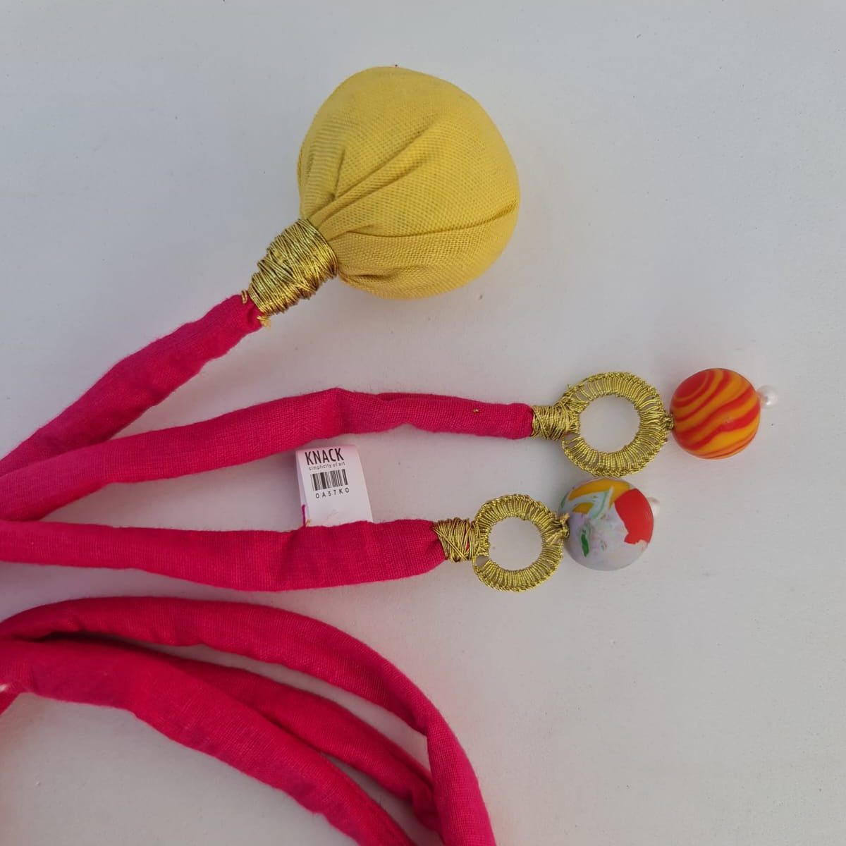 Pink fabric headband with decorative elements on a white background