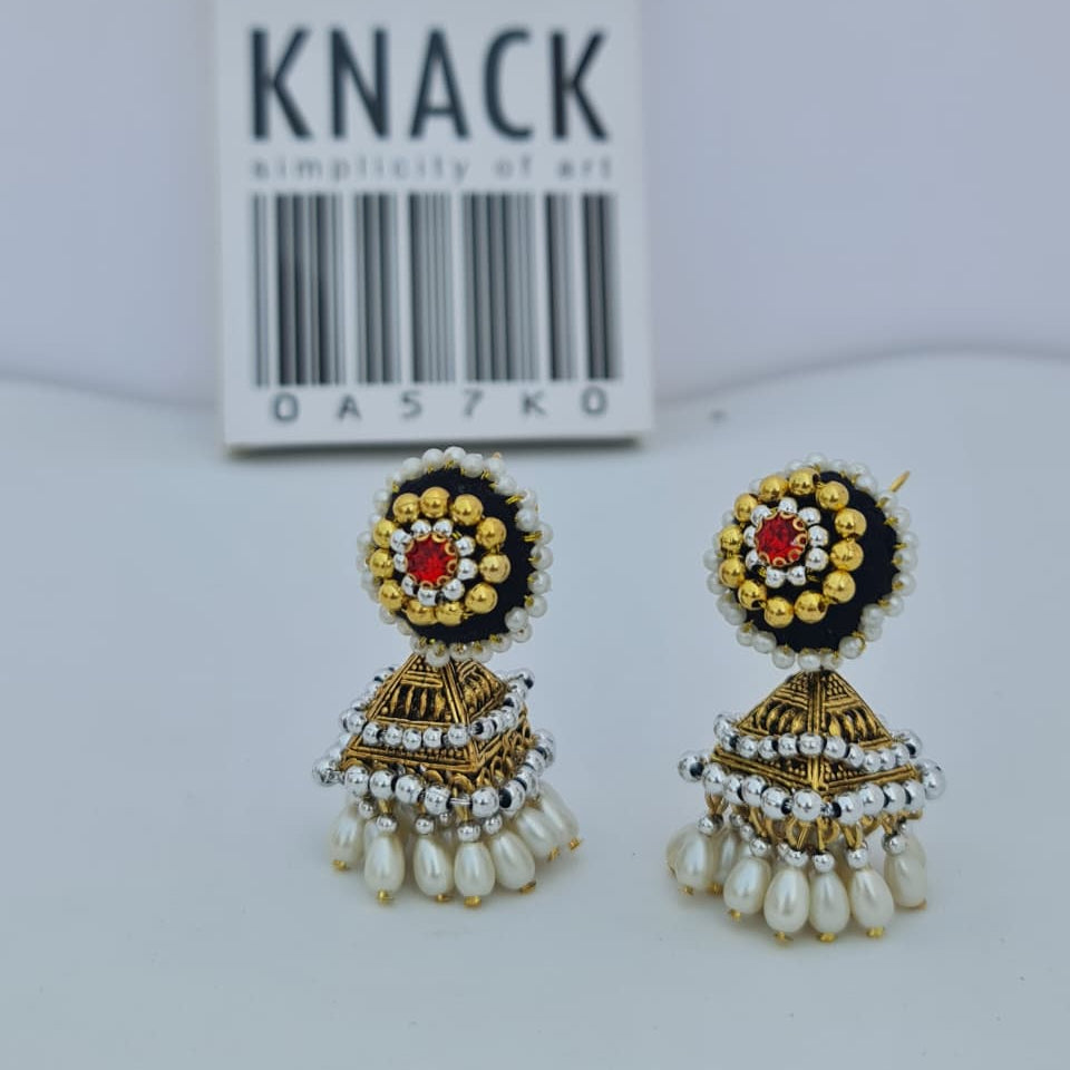Decorative earrings with intricate designs on a white background, featuring the brand 'Knack'.