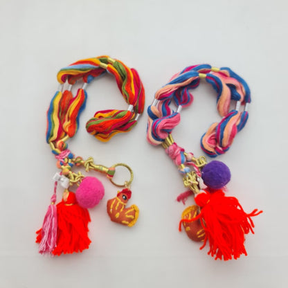Two colorful braided yarn keychains with tassels and charms, displayed on a plain white surface.